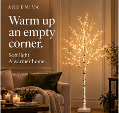 Winter Birch light tree with warm-white branches and a square base beside a sofa; styling illustration