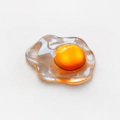 Yolk Glow Accent Light — playful fried-egg shaped table accent light with a warm center glow on a bedside table