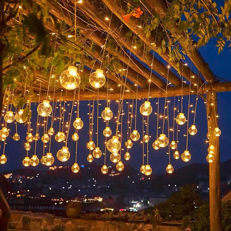 Hanging globe lights beneath a pergola at dusk; collection inspiration