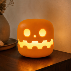 Ember Pumpkin Night Light glowing on a warm bedside table