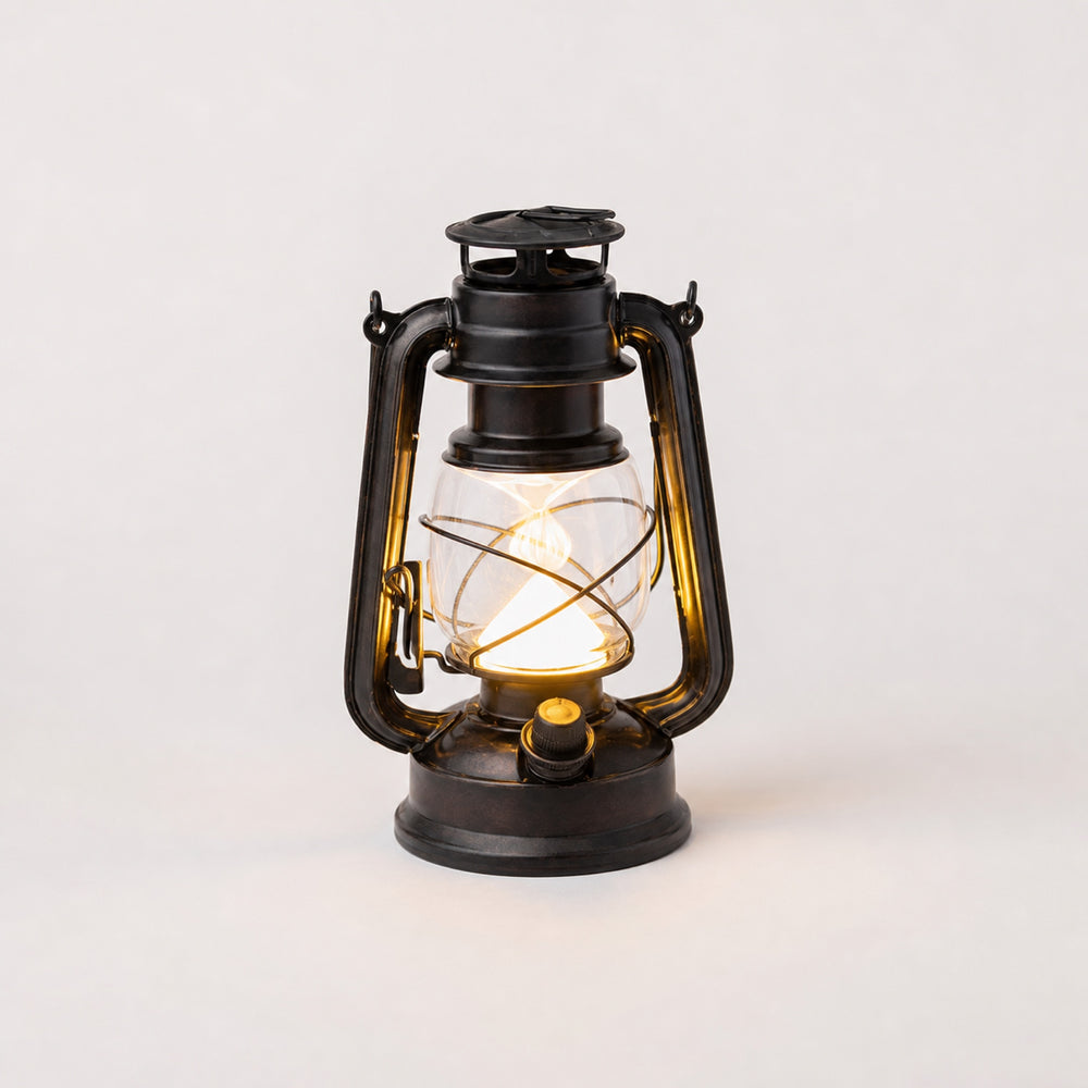 Haven Rechargeable LED Lantern — portable vintage-style black lantern with warm glow and carry handle on a patio table